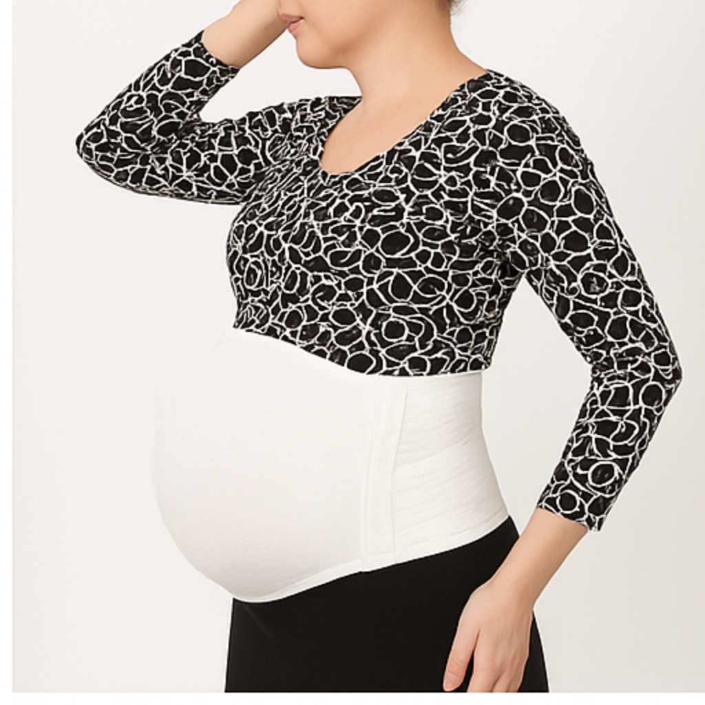 Pregnant woman wearing a black and white patterned long-sleeve top over a white shirt.