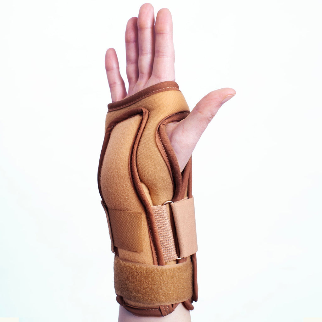 Hand with a tan wrist support brace on a white background